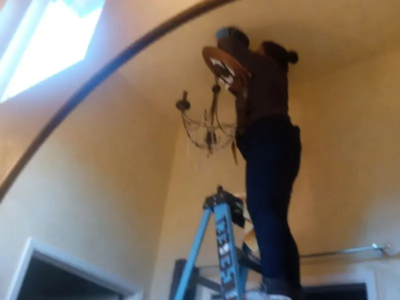 Electrician installing a chandelier in a Marlow residence